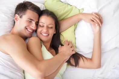 Guy and happy girl in bed